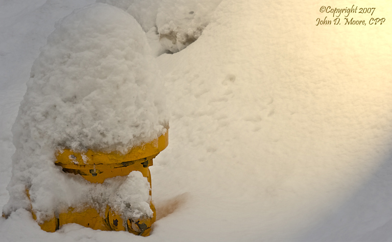 Snow covered fire hydrant in early Spokane darkness as street lights begin to illuminate the area.  