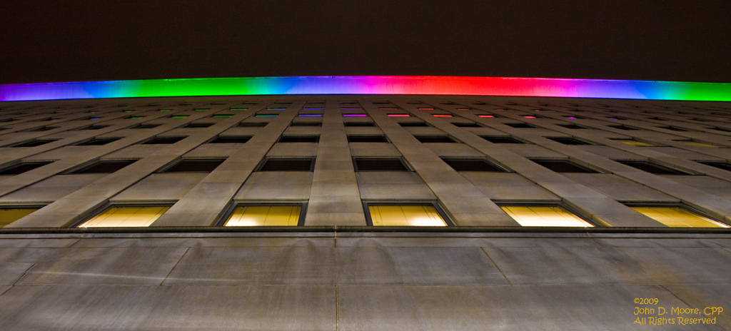 Looking directly up along the wall of the Lincoln Building, toward the rooftop colorful lighting display.