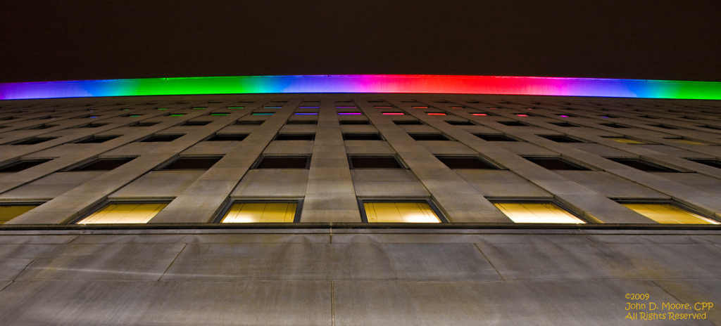 Looking directly up along the wall of the Lincoln Building, toward the rooftop colorful lighting display.