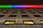 Looking directly up along the wall of the Lincoln Building, toward the rooftop colorful lighting display.